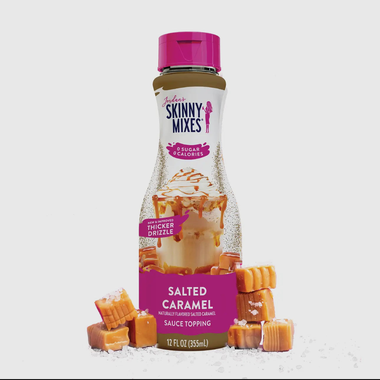 Bottle of Skinny Mixes Salted Caramel sauce topping with caramel candies on a white background