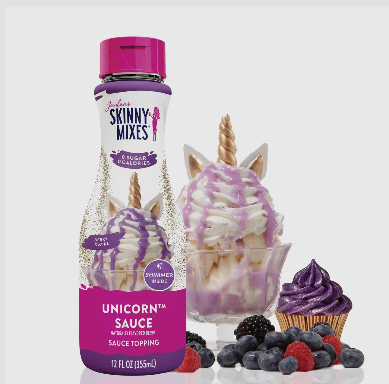 Bottle of Skinny Mixes Unicorn Sauce with dessert items on a white background